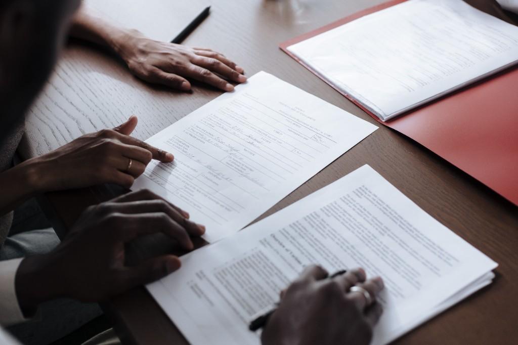 Legal professionals reviewing documents and case particulars at a desk before instructing an expert witness